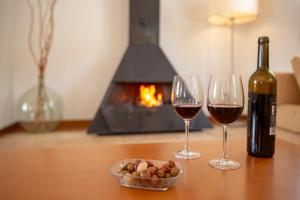 圣托马斯芬卡阿塔丽斯农家乐 - 仅限成人的一张桌子,上面放着两杯葡萄酒和一碗坚果