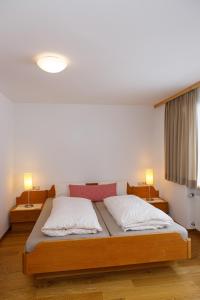 梅劳Haus Theresia的一间卧室配有一张带两个枕头的木床