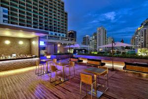 曼谷曼谷麗笙世嘉酒店 (Radisson Blu Plaza Bangkok)的屋顶酒吧设有桌椅,享有城市天际线