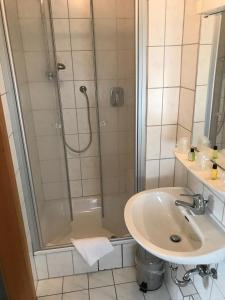 Knüllwald赫伯特汽车旅馆的带淋浴和盥洗盆的浴室
