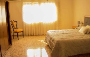 拉梅特拉·德·玛尔CAL SAMARRA的卧室配有床、椅子和窗户。