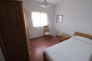 塔拉戈纳Apartament Tarracoliva的卧室配有床、椅子和窗户。