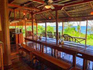 德雷克Las Caletas Lodge的餐厅设有木桌和长椅,享有海景。