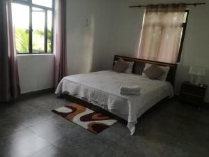 庞普勒穆斯JKB Villa的一间卧室设有床、窗户和地毯。