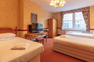 格洛斯特The New Inn by Roomsbooked的酒店客房设有两张床和电视。