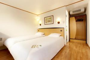 盖斯波尔塞姆钟楼斯塔伯格伊吉奇杰斯坡谢姆酒店的配有白色床单的客房内的两张床