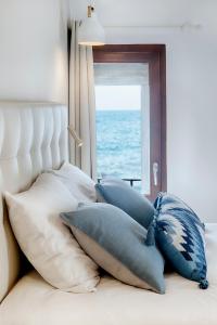 阿尔啼Hostal Altea House的一堆枕头坐在床上,靠窗