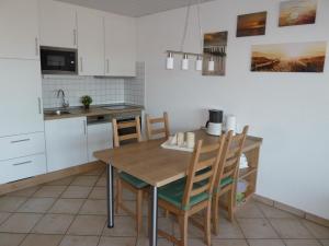 西里格Wangeroogeweg 5a的厨房配有木桌和椅子