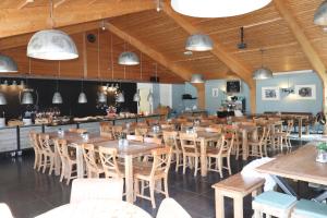 霍勒姆Sier aan Zee的大型用餐室配有木桌和椅子