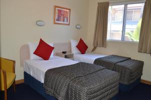 布里斯班Airport Motel Brisbane的酒店客房设有两张床和窗户。