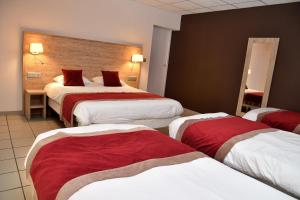 米洛Hotel Restaurant du Bowling de Millau的酒店客房,设有三张铺有红白床单的床