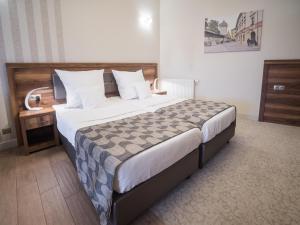 克拉科夫Hotel Miodowa的酒店客房设有一张大床和一张书桌。