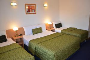 布里斯班Airport Motel Brisbane的酒店客房设有两张床和两盏灯。
