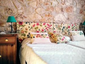 HuertaCasa rural Estrella Polar I的一间卧室配有带枕头的床铺和石墙