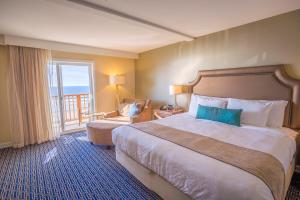 新港奈海滩旅馆的酒店客房设有一张大床和一个阳台。
