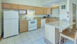 东斯特劳兹堡Pocono Villas Resort的厨房配有白色冰箱和木制橱柜。