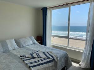拉塞雷纳La Serena Laguna del Mar hasta 8 personas espectacular departamento的一间卧室配有一张床,享有海滩美景