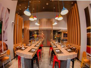 伊基克ibis Iquique的大型用餐室配有长桌子和红色椅子