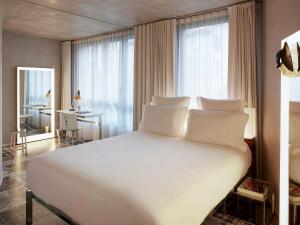 马赛马赛玛玛屋公寓式酒店的卧室配有一张白色大床和一张书桌