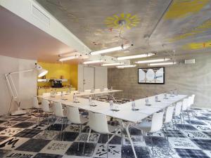马赛马赛玛玛屋公寓式酒店的一间会议室,配有长桌和白色椅子