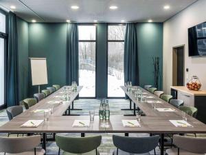 斯图加特ibis Styles Stuttgart Vaihingen的大型会议室,配有长桌子和椅子