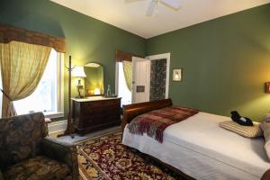 哈蒙兹波特Black Sheep Inn and Spa的卧室配有床、椅子和窗户。