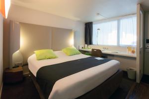 茹埃莱图尔南图尔〜图尔瑞恩钟楼酒店的酒店客房配有一张带黄色枕头的大床