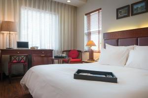 河内Hanoi E Central Luxury Hotel & Restaurant的一间酒店客房,配有一张带托盘的床