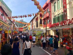 新加坡BEAT Arts Hostel at Chinatown的一群人沿着街道走着,街道上有许多建筑