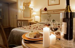 伊洛伊洛The Grand Dame Hotel的一张桌子,上面放着一盘食物和一瓶葡萄酒