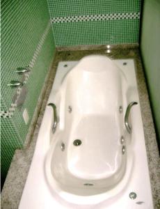 马卡埃罗莎马尔酒店的带浴缸的浴室和绿色的墙壁