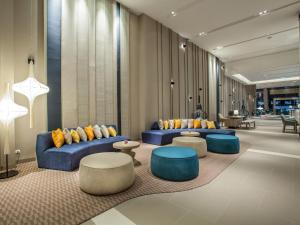 芭堤雅市中心芭堤雅美居海洋度假酒店的大堂设有蓝色的沙发和桌椅