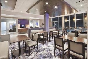 奥克莫斯Holiday Inn Express & Suites Okemos - University Area, an IHG Hotel的用餐室设有桌椅和窗户。