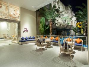 芭堤雅市中心芭堤雅美居海洋度假酒店的大堂设有椅子和恐龙墙