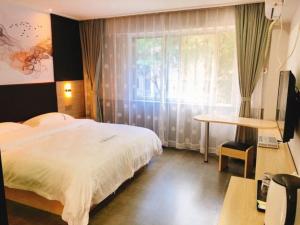 深圳深圳市华联精品酒店的一间卧室配有一张床、一张书桌和一个窗户。