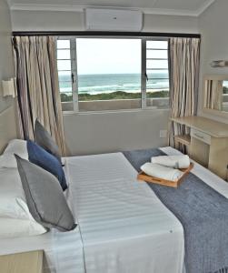 阿曼济姆托蒂Sunrise Beach Resort的一间卧室设有一张床,享有海景