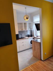 卡托维兹B&B MILES APARTMENT的厨房配有白色家电和黄色墙壁