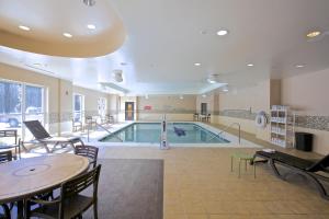 德卢斯Holiday Inn Express & Suites Atlanta NE- Duluth, an IHG Hotel的游泳池位于带桌椅的房间