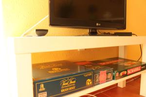 安波拉Apt ideal para familias cerca del mar的两个比萨饼盒,放在一个带电视的架子上
