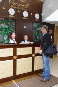 圣彼得堡斯特雅纳亚克伦威尔客旅馆的一名男子和两名妇女站在柜台上