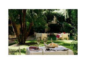 罗马奎里纳莱酒店的花园里的桌子,上面有酒杯和雕像