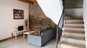 AnserallAllotjament Rural Cal Miquel的带沙发和楼梯间的客厅