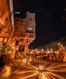 Aït IdaïrHotel Riad Bahammou的庭院在晚上配有桌椅