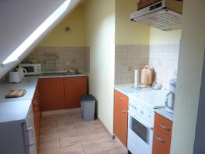 Burg KauperFerienwohnung Lehmann, Ursel的厨房配有橙色橱柜和白色炉灶烤箱