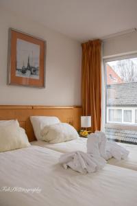 法尔肯堡法肯堡2000酒店的一间卧室配有一张带白色床单的床和一扇窗户。