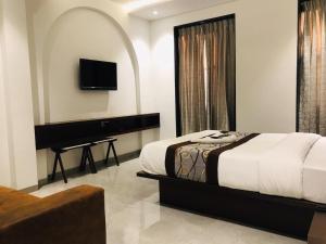 孟买Hotel Flora Suites - Fort的一间卧室配有一张钢琴床和一张四柱床