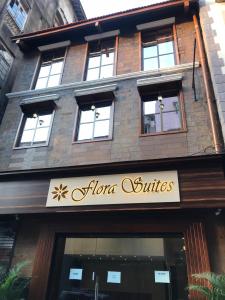 孟买Hotel Flora Suites - Fort的建筑前有标志的商店