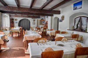 韦尔科尔地区朗Hotel du Col de l'Arc的餐厅配有桌椅和白色的桌布