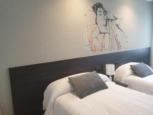 维多利亚-加斯特伊兹Hotel Arts - Gasteiz Centro的一间卧室设有两张床,墙上挂着一幅画