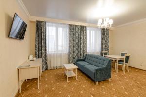 苏尔古特Hotel Aquamarin的客厅配有蓝色的沙发和桌子